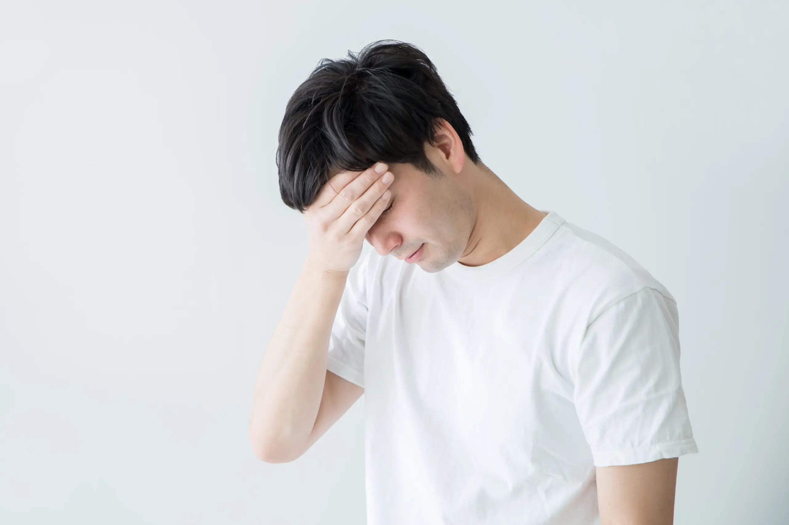 頭をおさえる男性