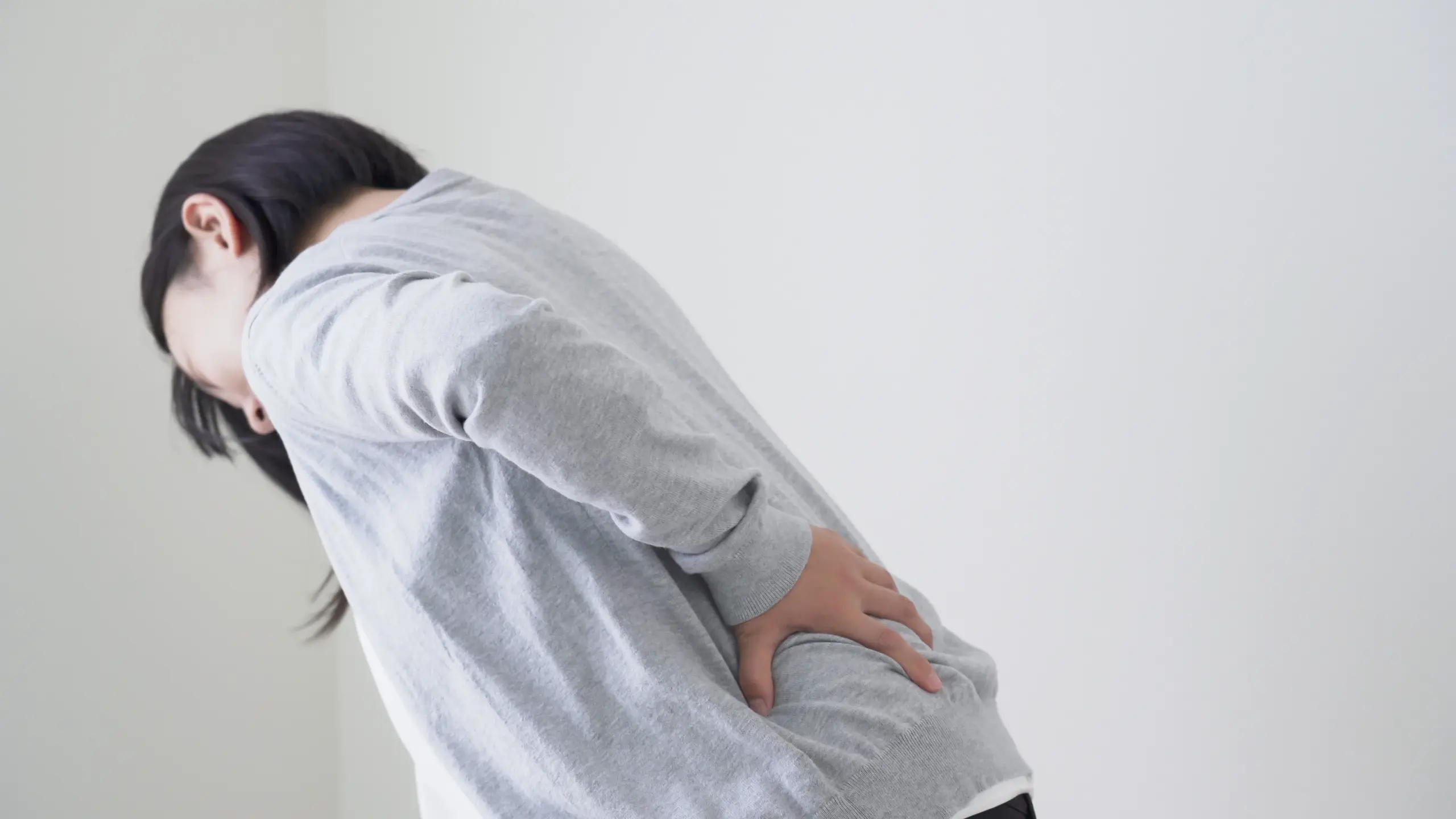 腰をおさえる女性