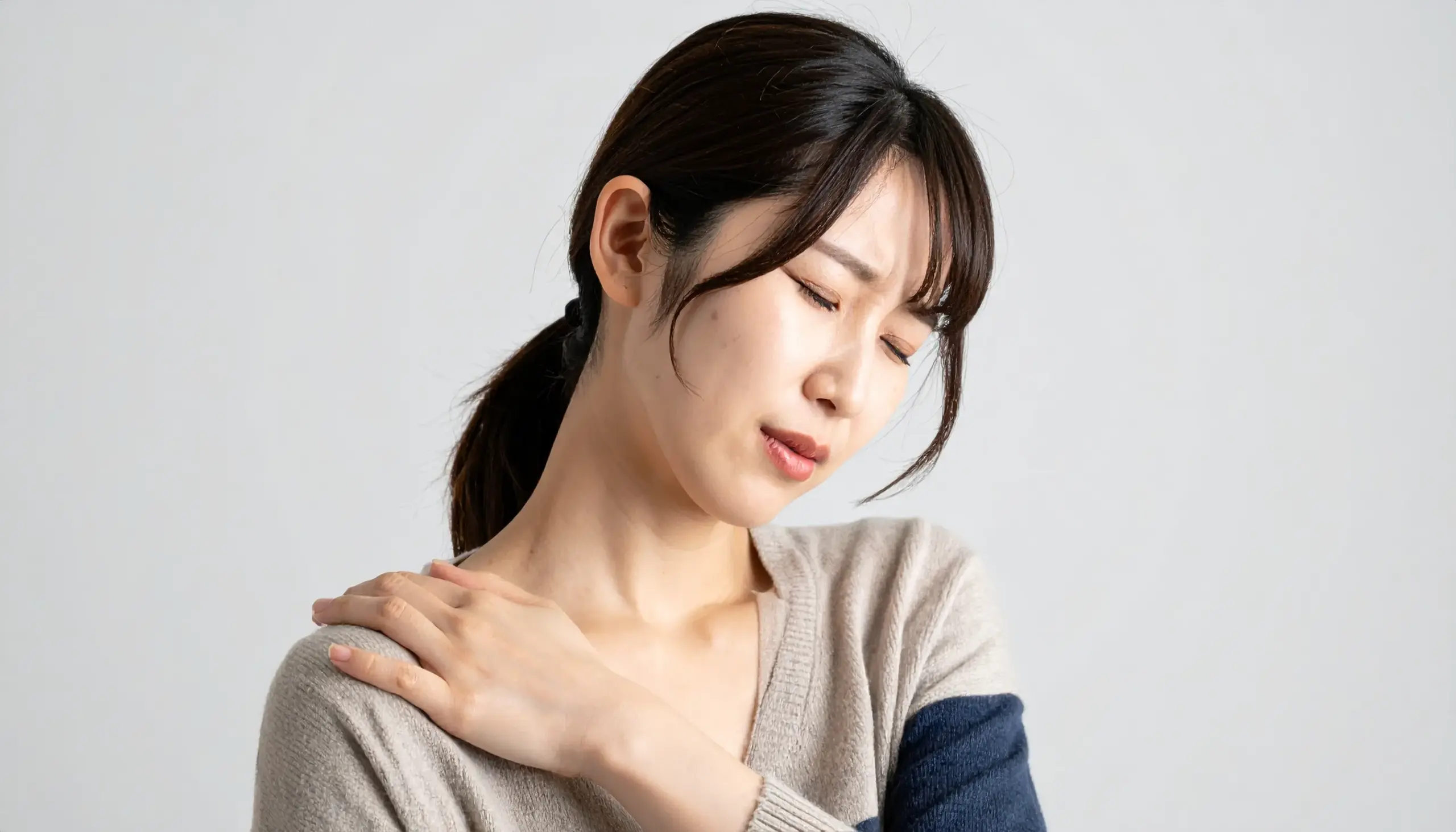 首をおさえる女性