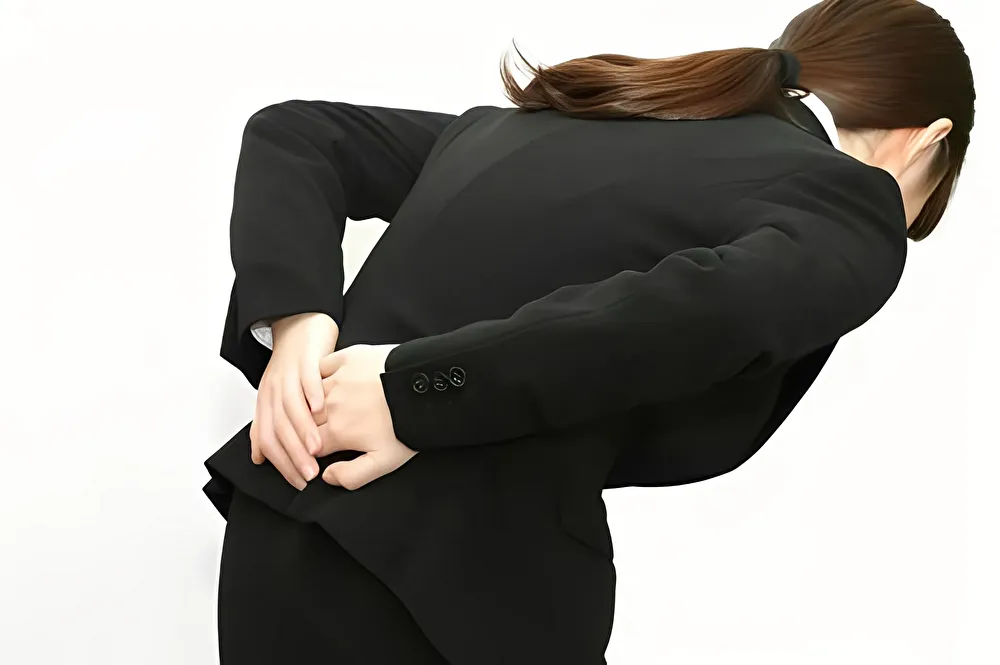 腰をおさえる女性